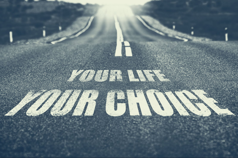 A road with the words "Your life, your choice" painted on it.